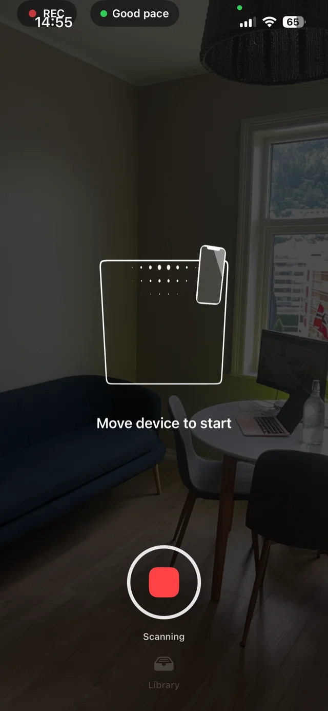 HouseTour-appen ber megleren flytte telefonen for å starte skanning av stuen